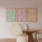 Three Matisse art prints on a wall above a wooden table and chairs.