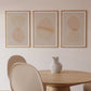 Dining room with a wooden table, white chairs, and abstract art on the wall.